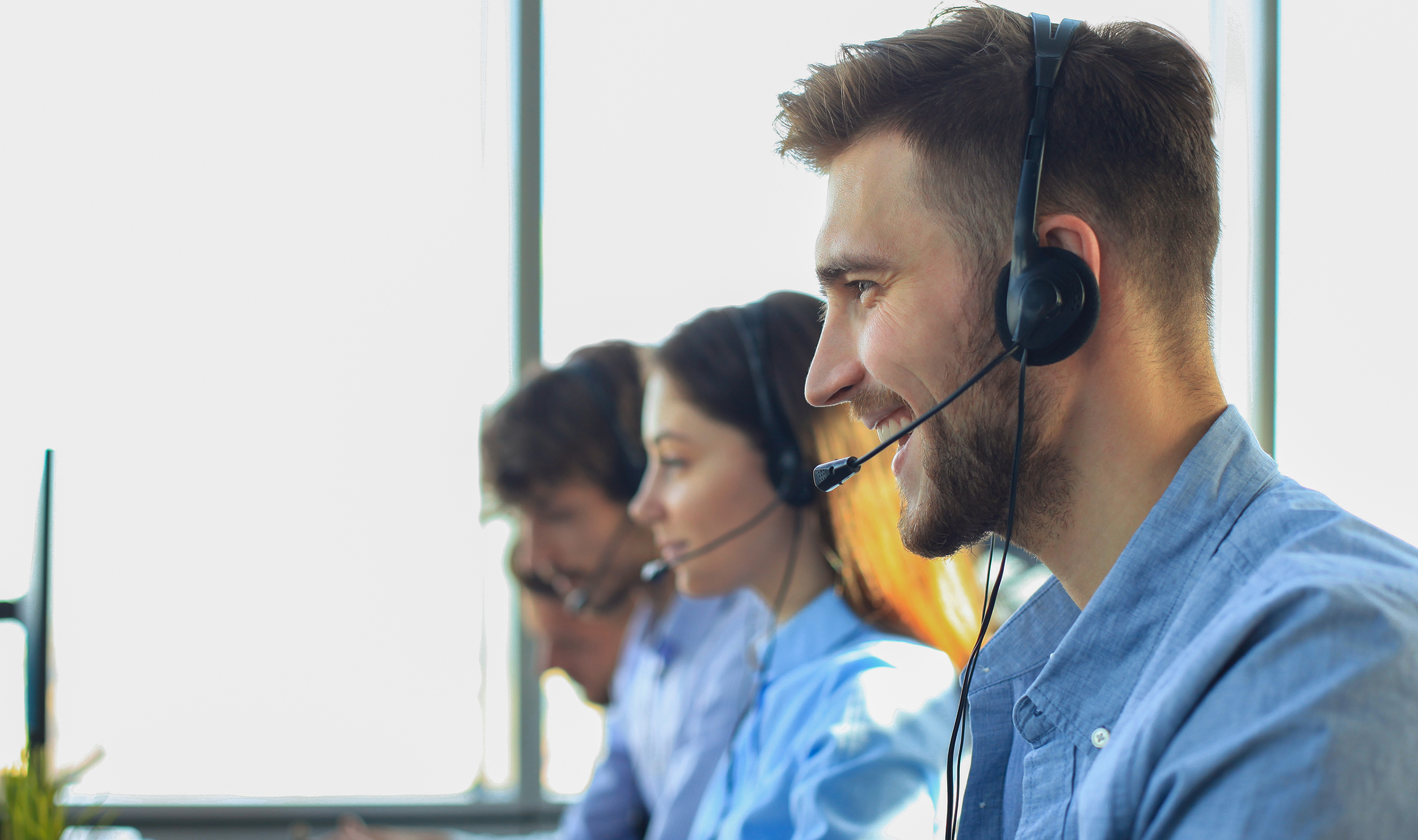 Attractive positive young businesspeople and colleagues in a call center office.