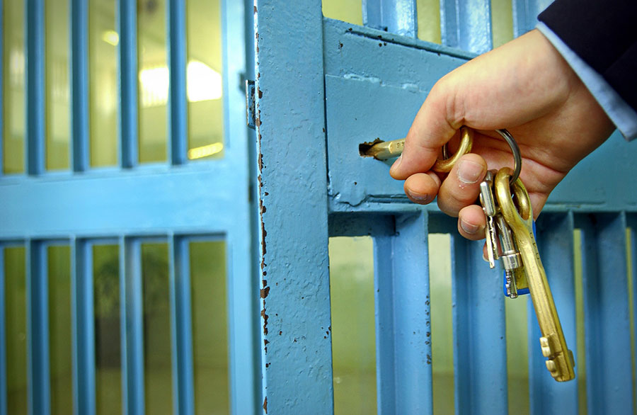 Prison guard locking cell with key. How safe do your staff feel